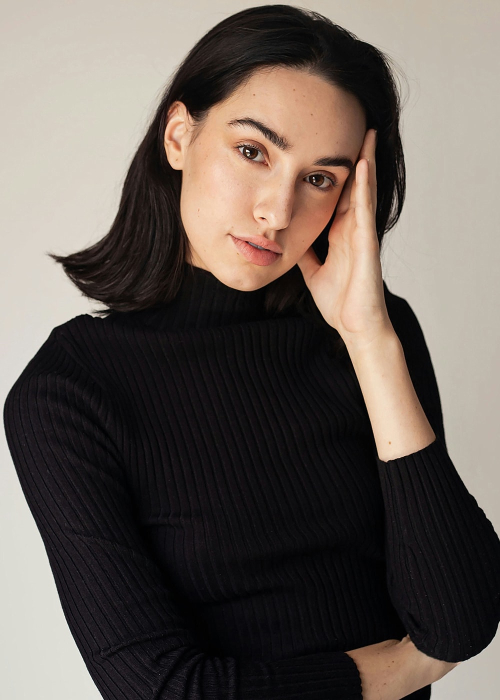 Model in black turtleneck, thoughtful expression.