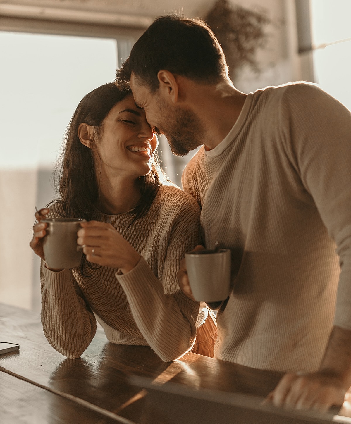 Couple enjoying coffee in warm, intimate setting.