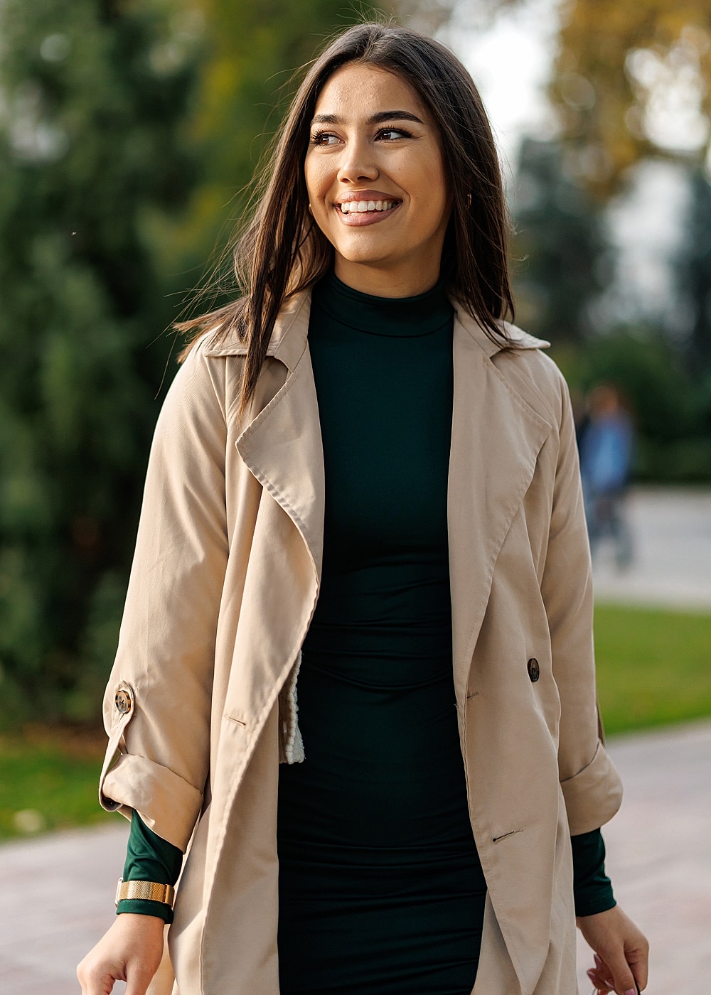 Woman smiling in stylish outerwear outdoors.