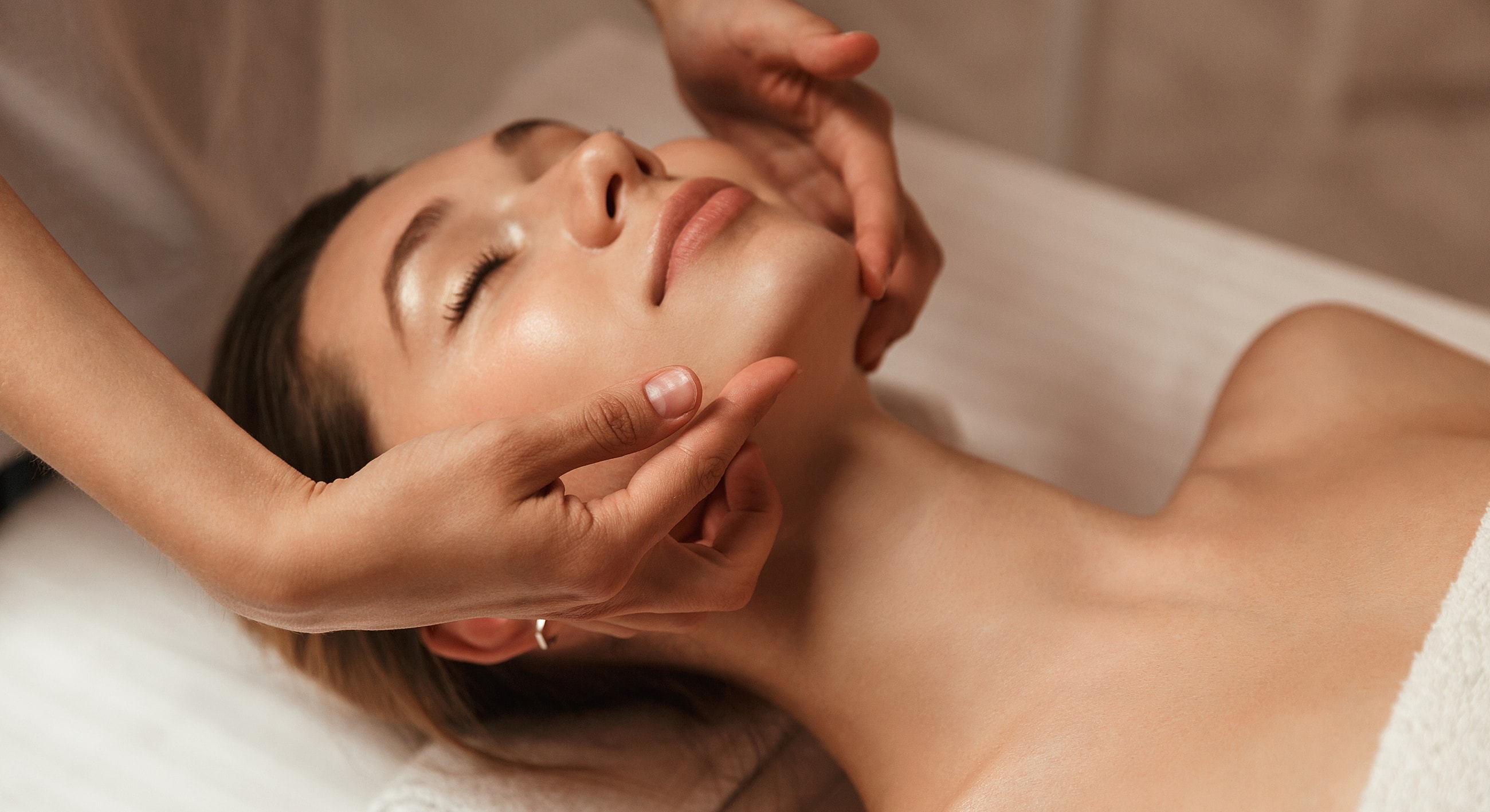 Woman enjoying a relaxing facial massage treatment.